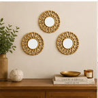Three small golden round wall mirrors arranged above a console table