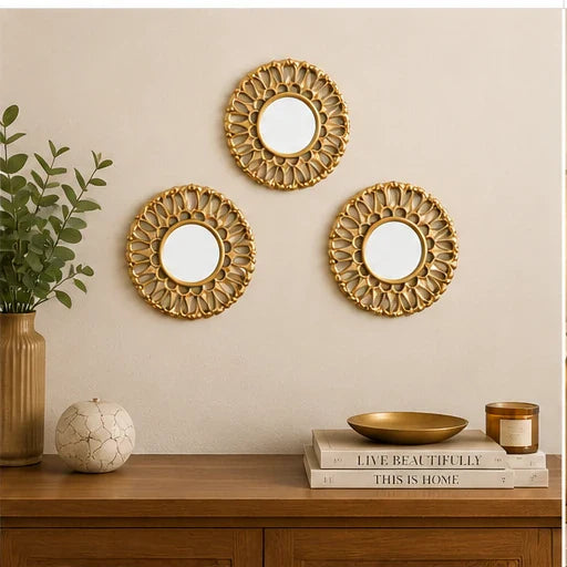 Three small golden round wall mirrors arranged above a console table